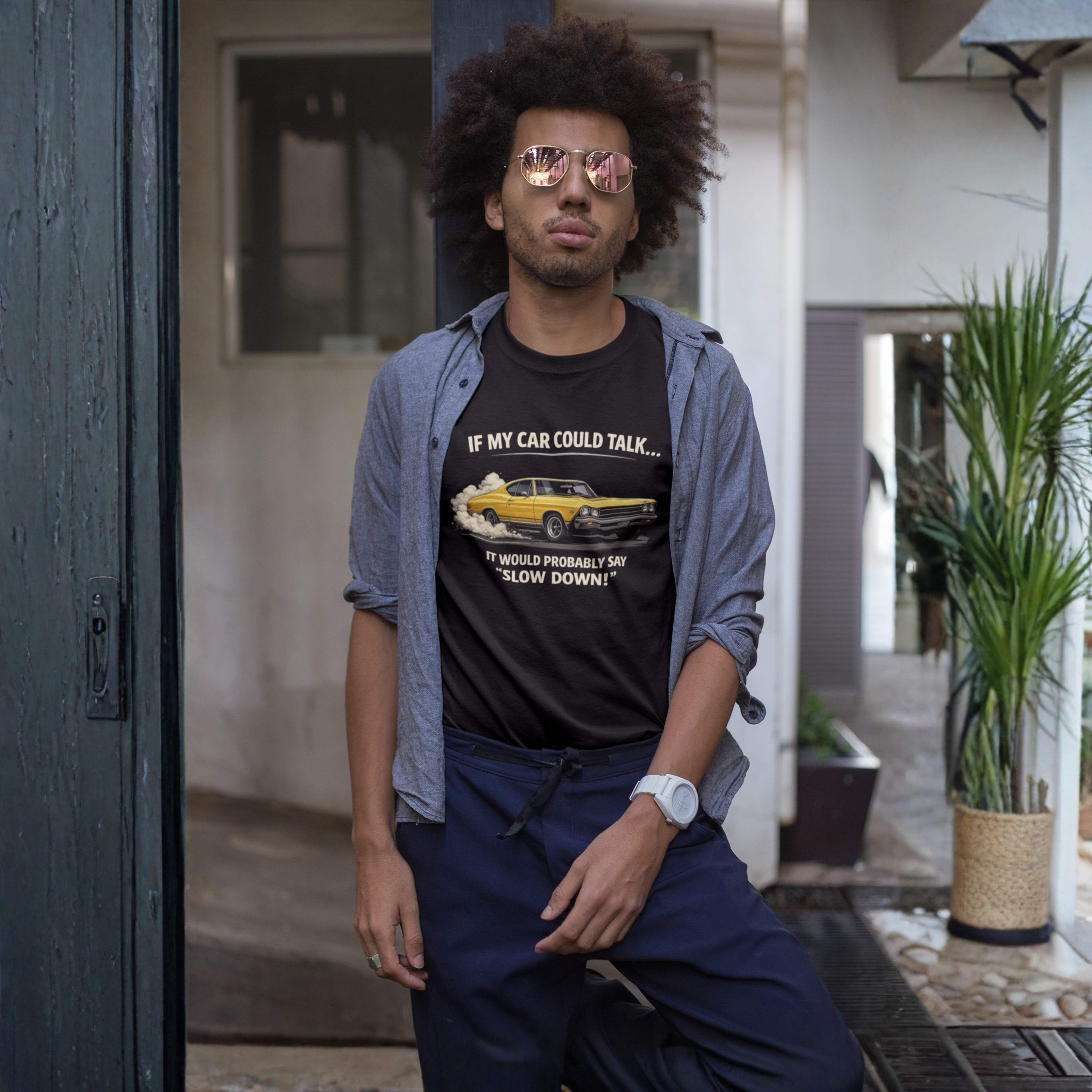 Man wearing a black t-shirt with a graphic and text, sitting outdoors.
