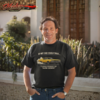 Man wearing a black t-shirt with a car-themed graphic and text, standing outdoors.