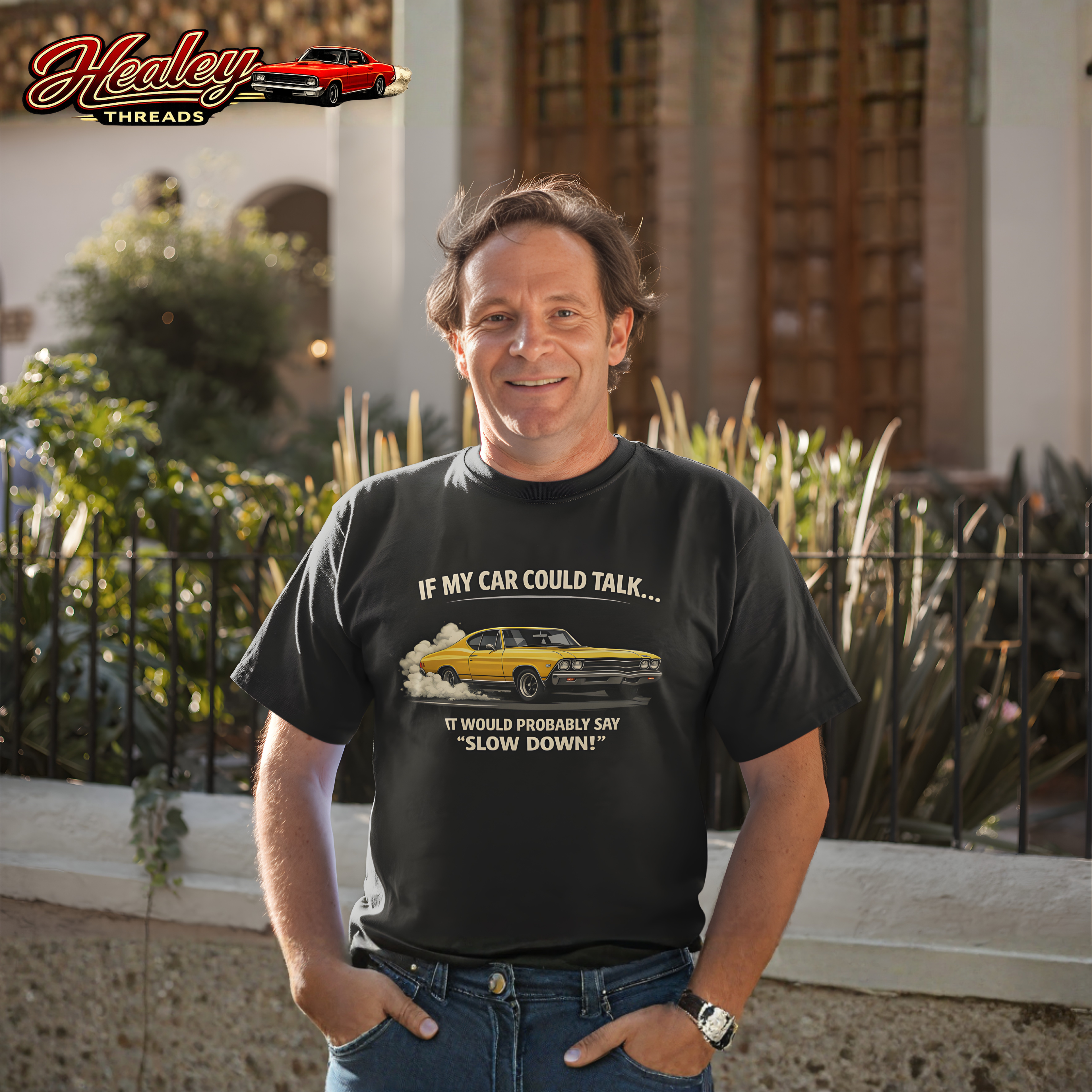 Man wearing a black t-shirt with a car-themed graphic and text, standing outdoors.