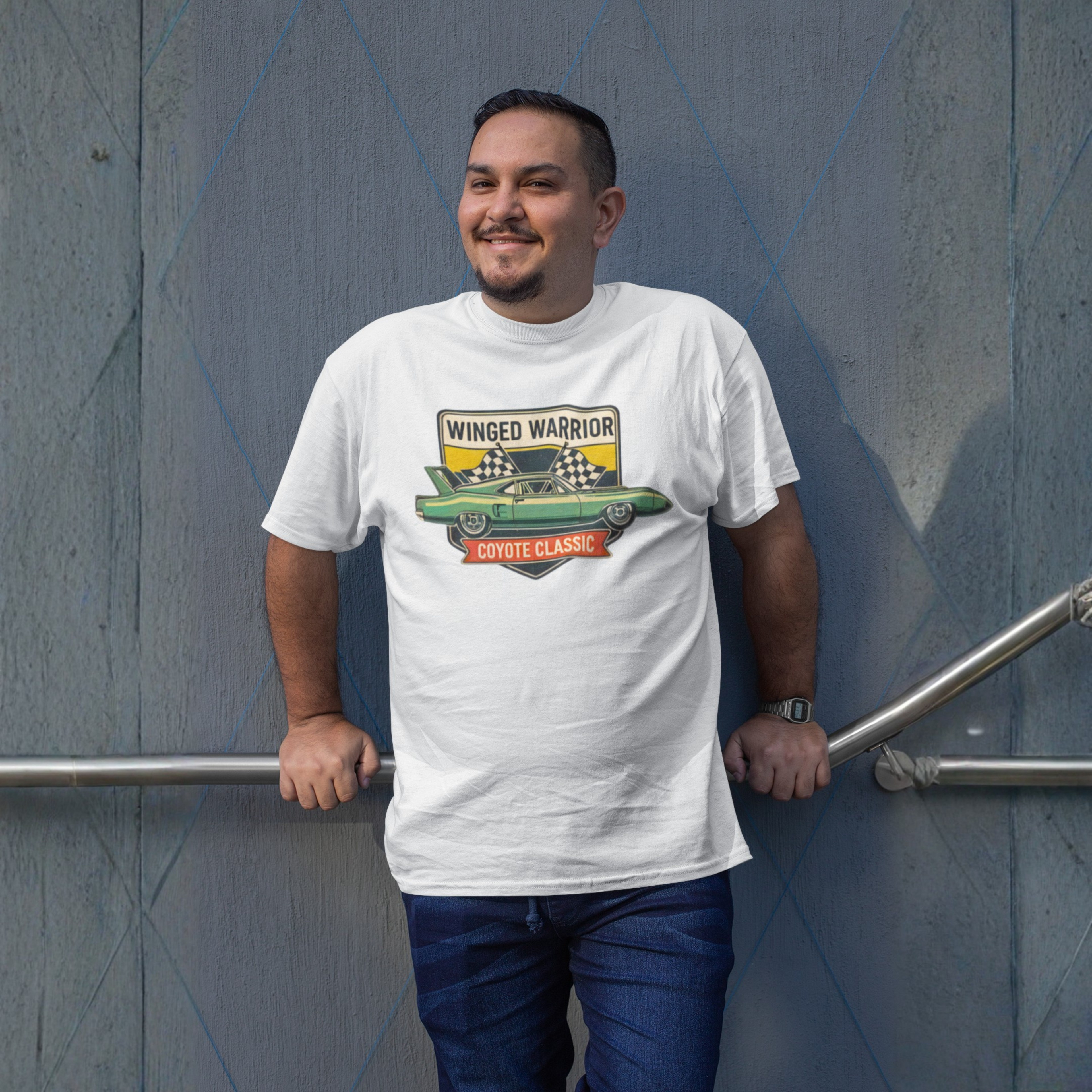 Man wearing a white t-shirt with a graphic design, standing against a gray wall.
