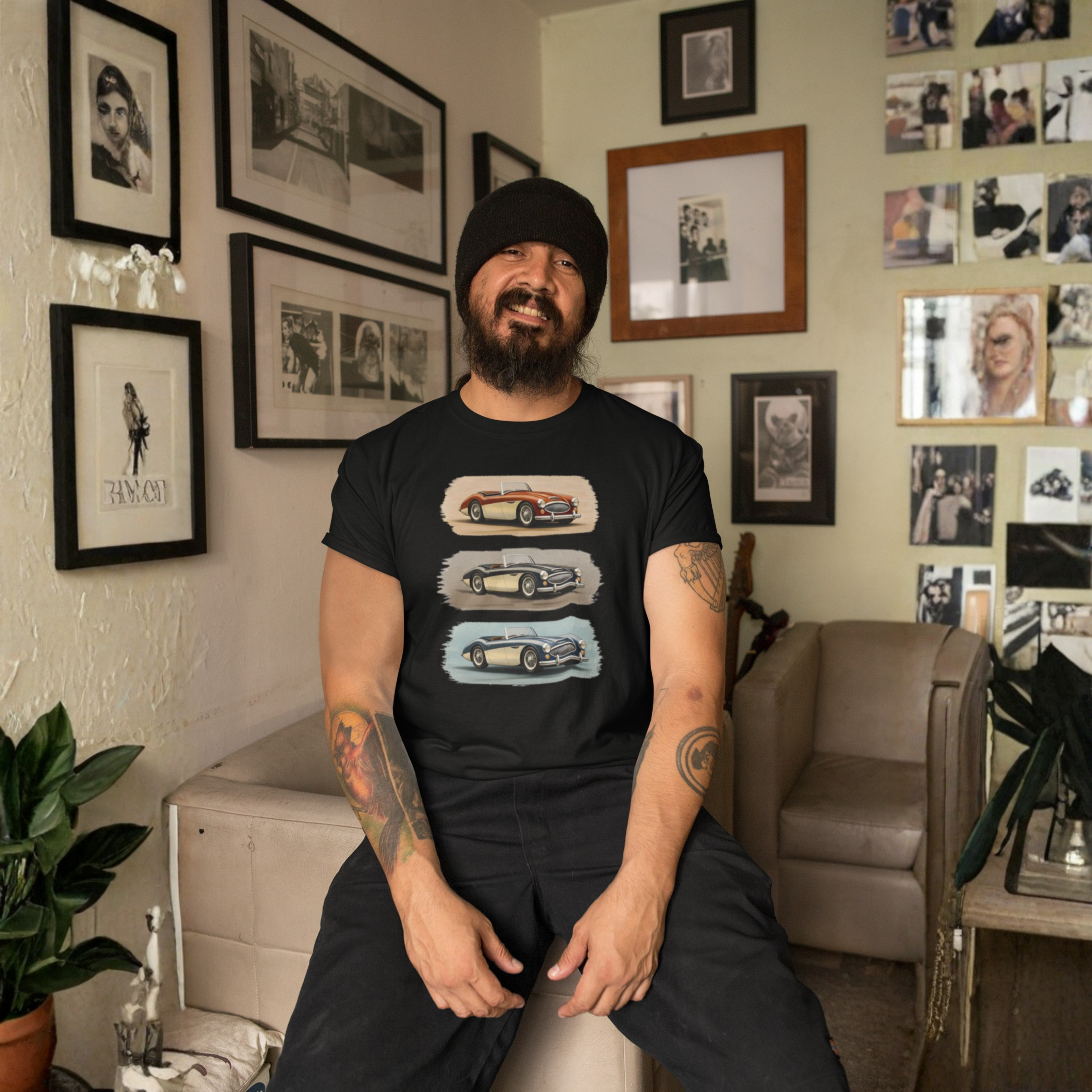 Man wearing a black Healey t-shirt with car graphics in a living room setting