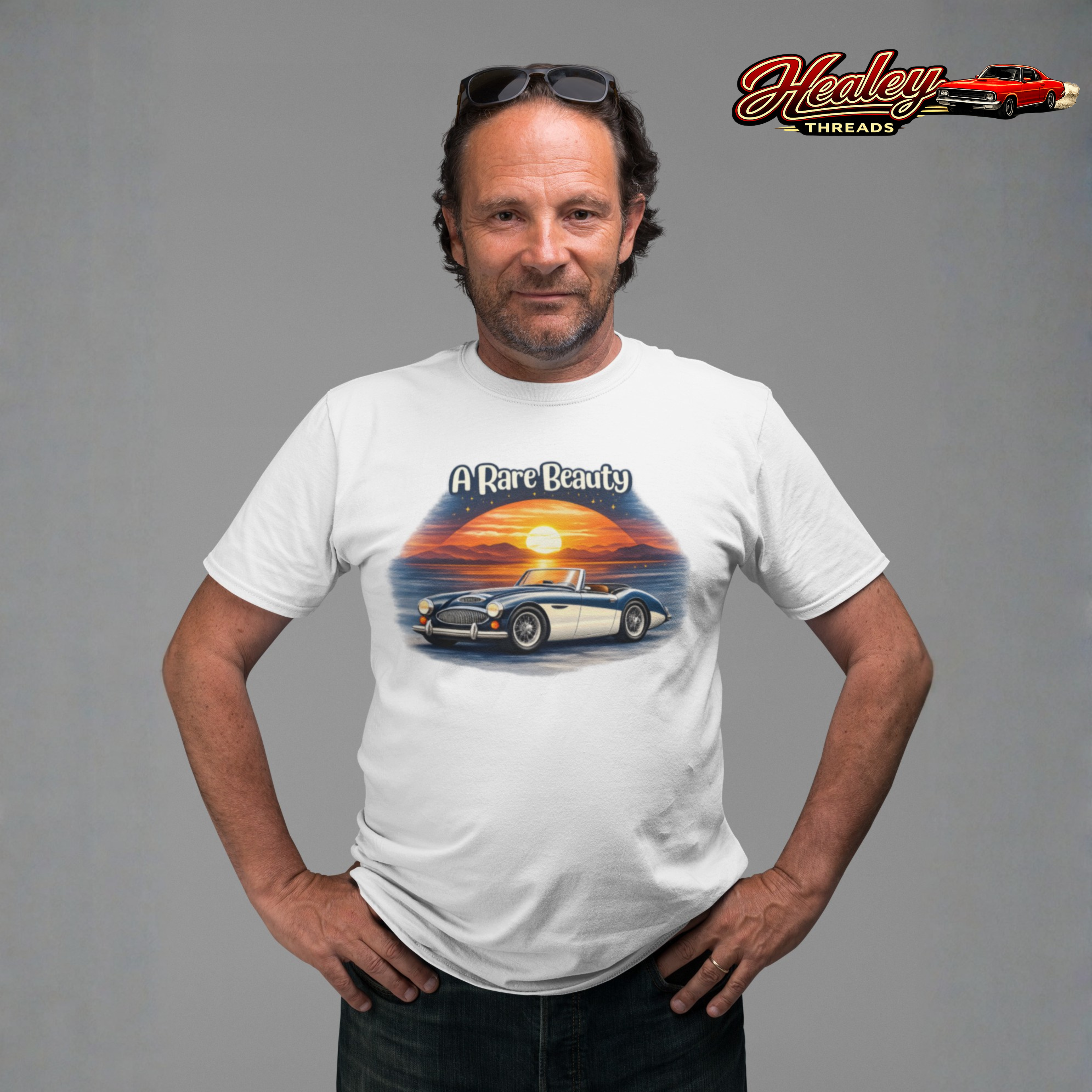 Man wearing a white t-shirt with a car graphic sunset and 'Healey Threads' logo.
