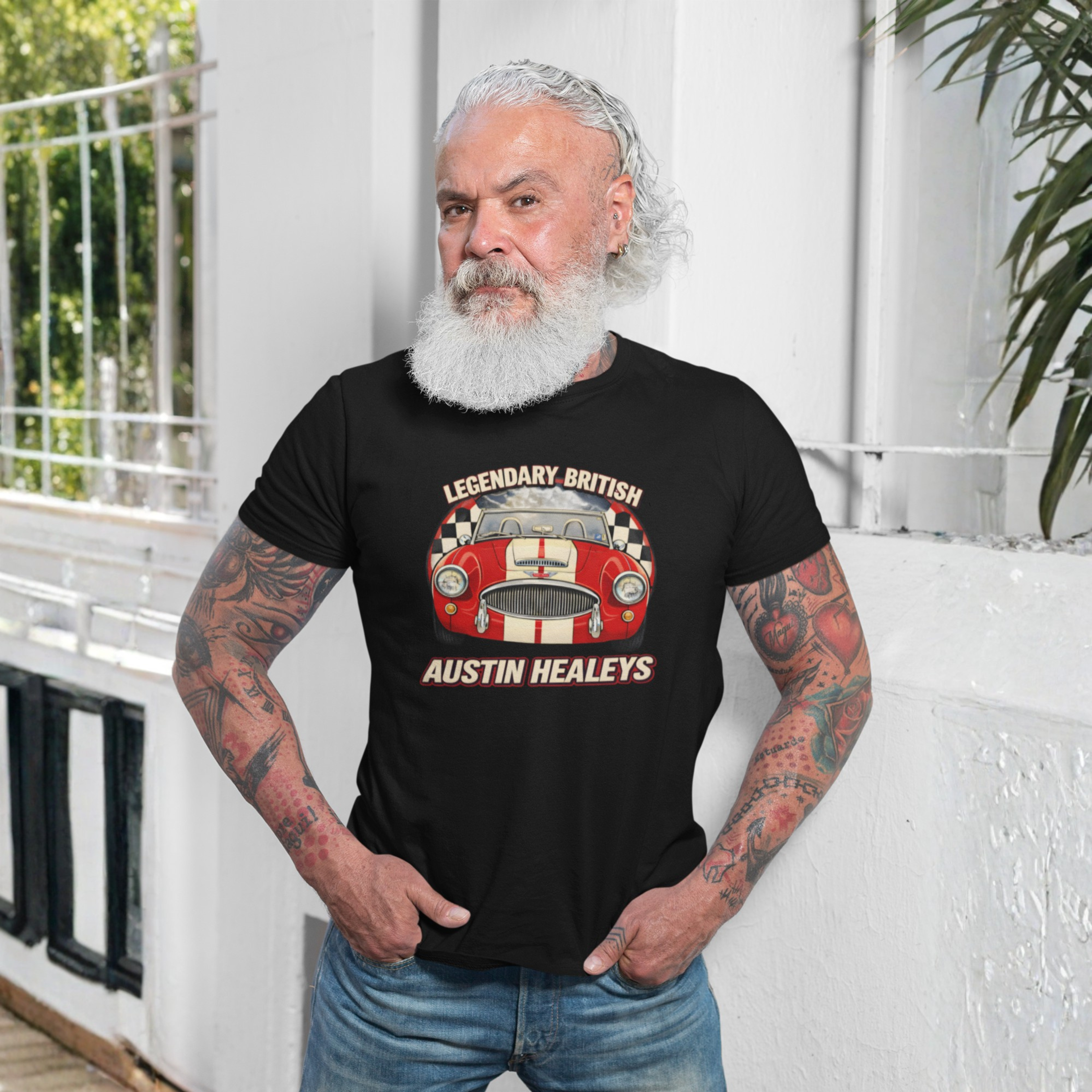 Man wearing a black t-shirt with an Austin Healey design, standing outdoors.