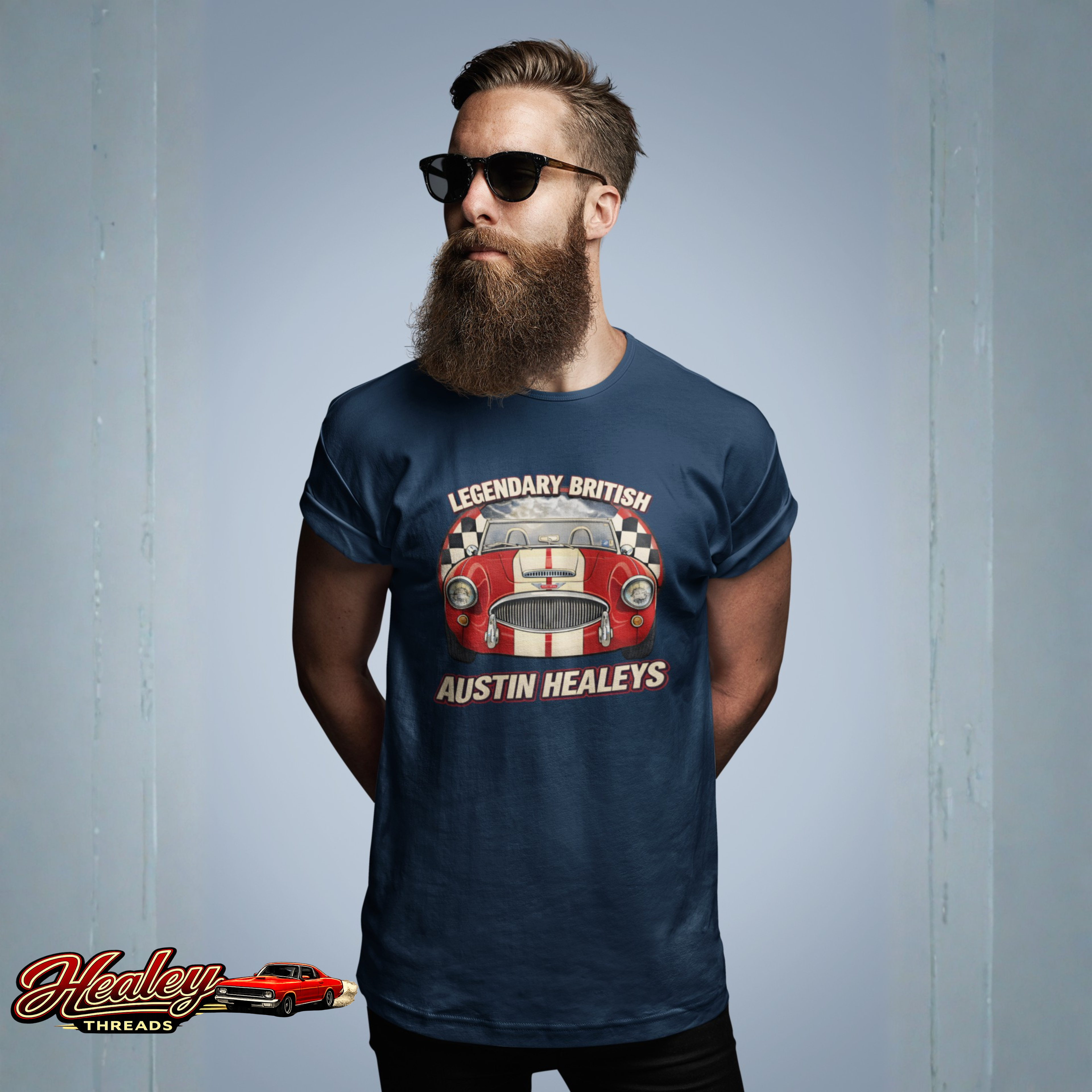 Man wearing a navy blue t-shirt with an Austin Healey graphic against a gray background
