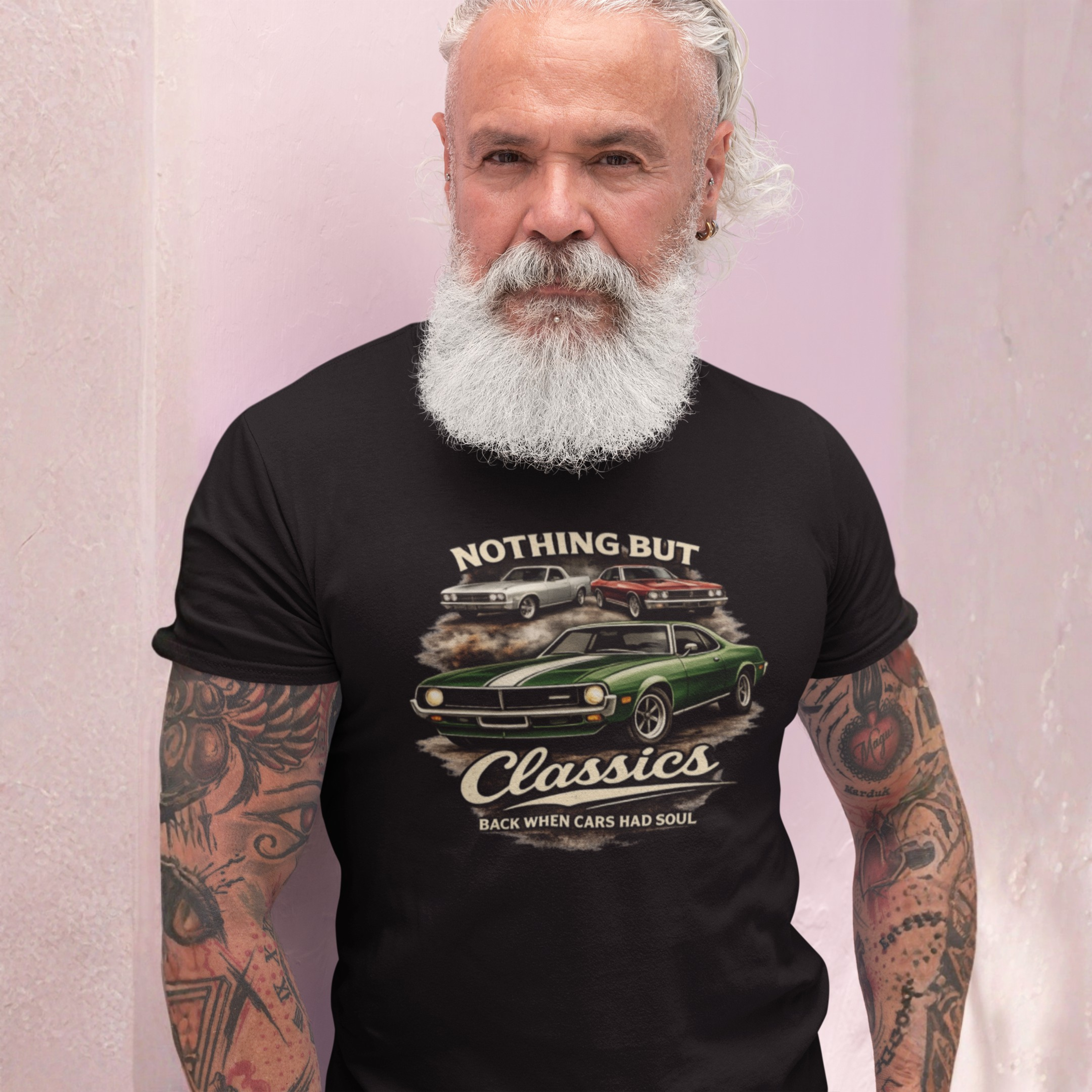 Man wearing a black t-shirt with classic car graphic and text on a pink background