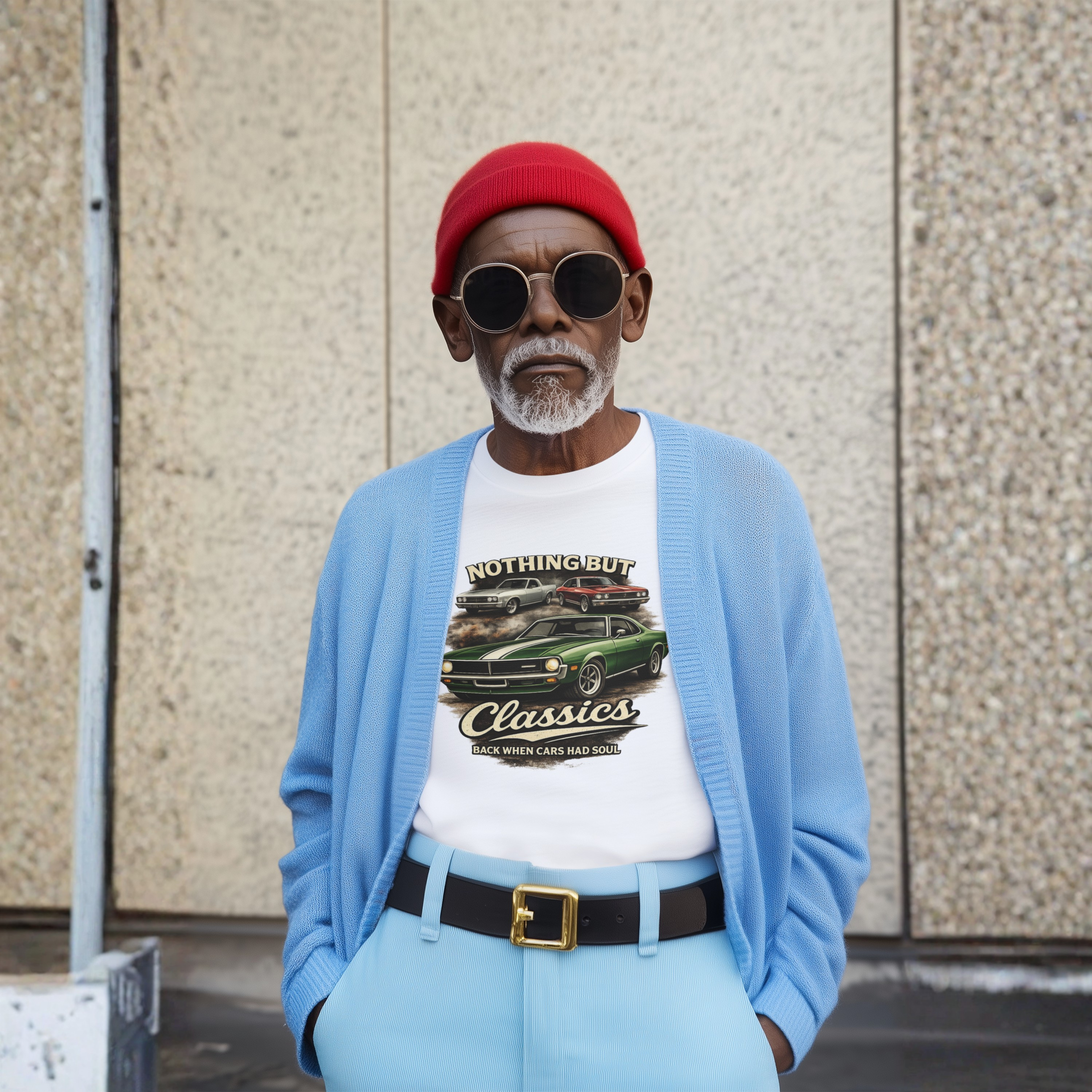 Man wearing a red cap, sunglasses, and a light blue cardigan over a graphic t-shirt against a textured wall.