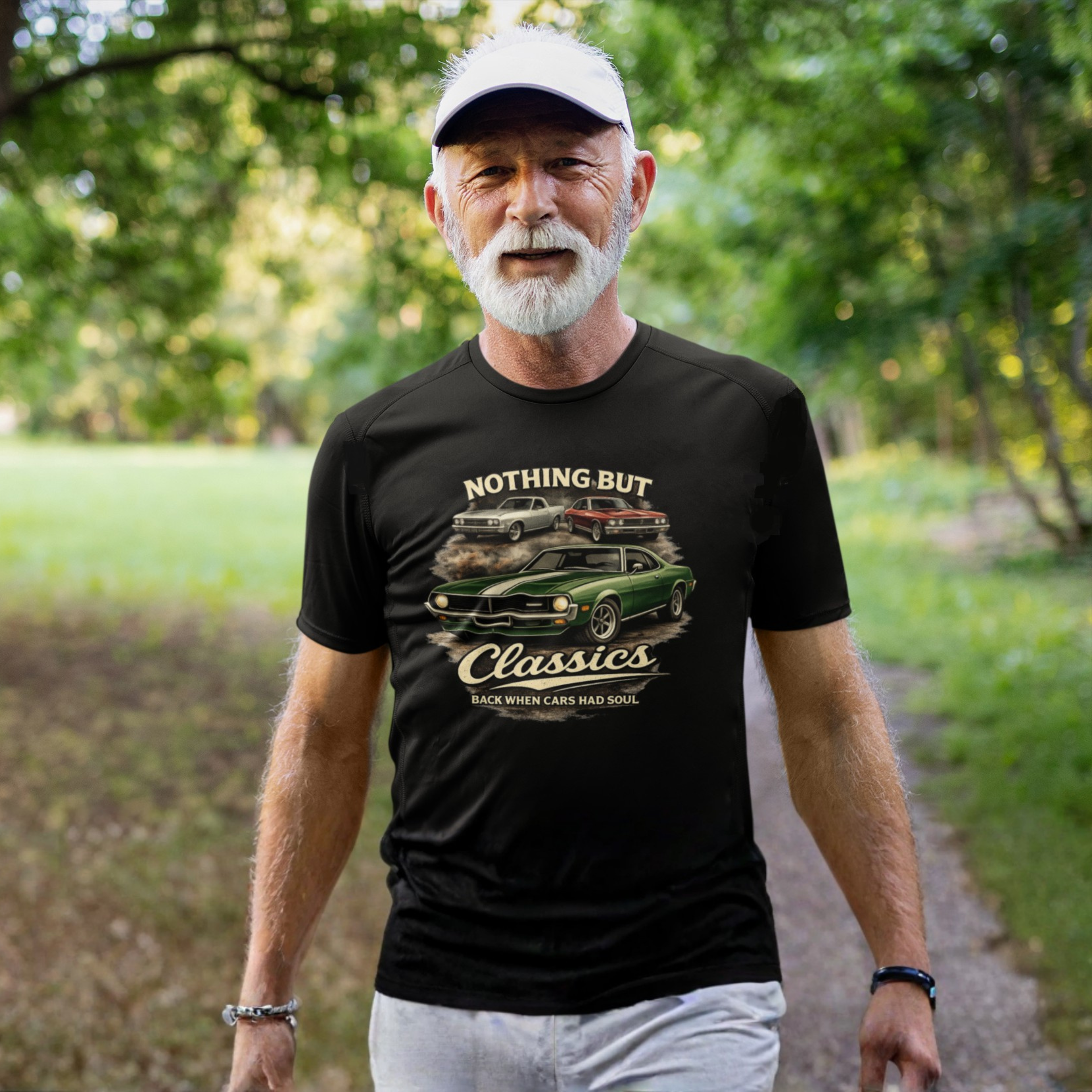 Man wearing a black t-shirt with a graphic design of classic cars and text, standing outdoors.