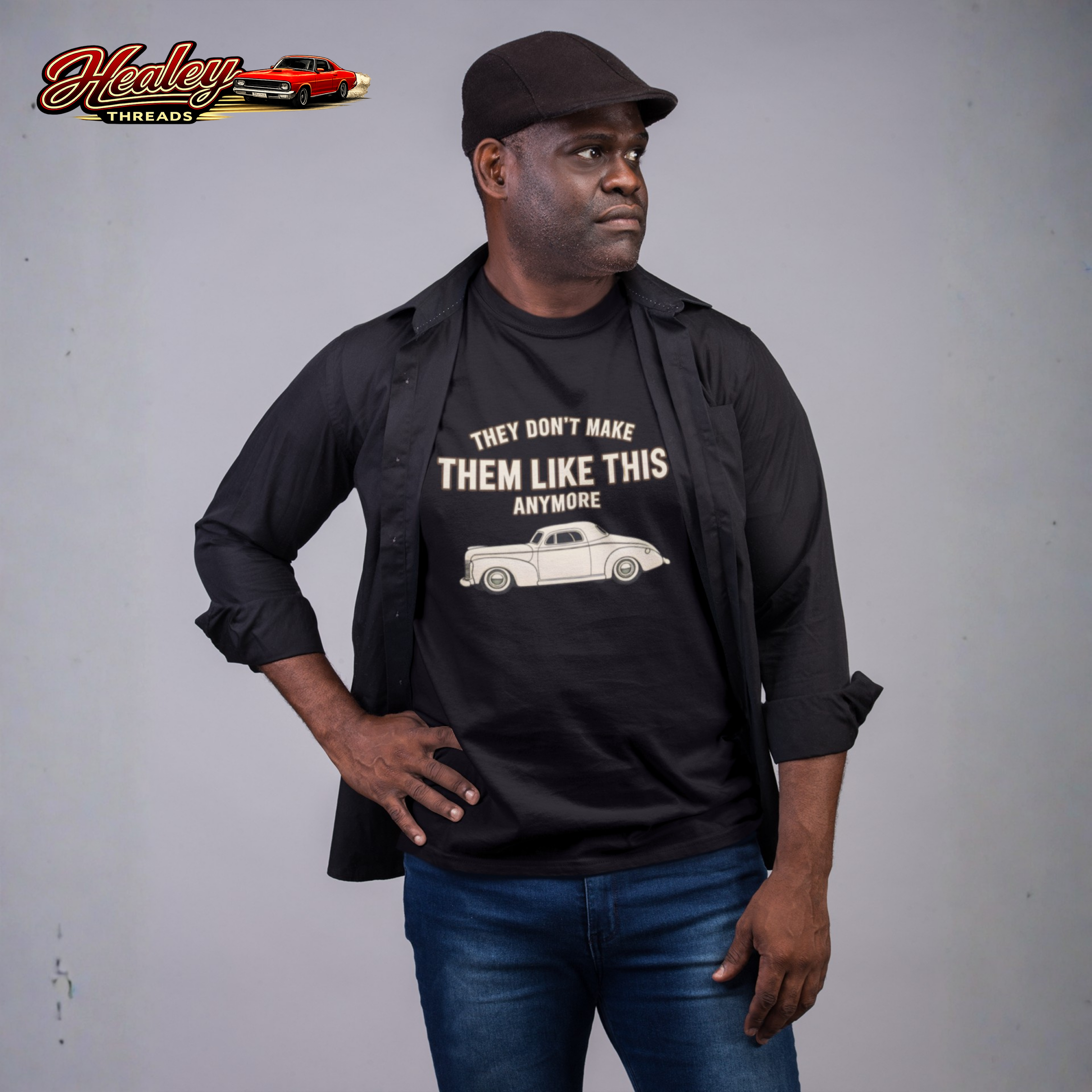 Man wearing a black t-shirt with a graphic and text, standing against a plain background.