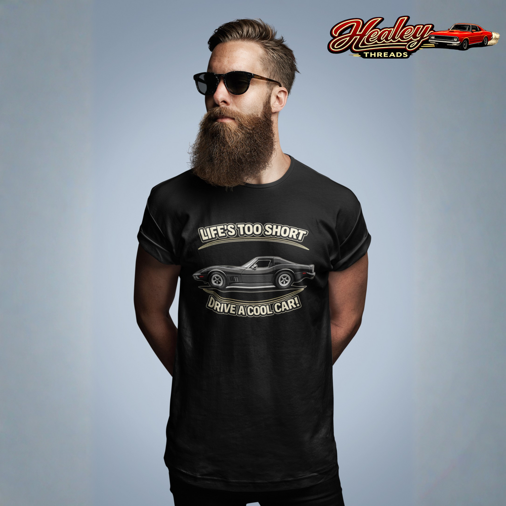 Man wearing a black t-shirt with a graphic vintage vette design and text, standing against a gray background with 'Healey Threads' branding.