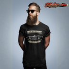 Man wearing a black t-shirt with a graphic vintage vette design and text, standing against a gray background with 'Healey Threads' branding.