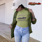Woman wearing a green t-shirt with a vintage vette graphic and text, standing outdoors.