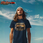Man wearing a navy blue t-shirt with a classic car graphic design against a blue sky.