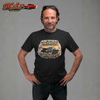 Man wearing a black t-shirt with a classic car graphic design and text, standing against a gray background. Healey Threads logo is visible.