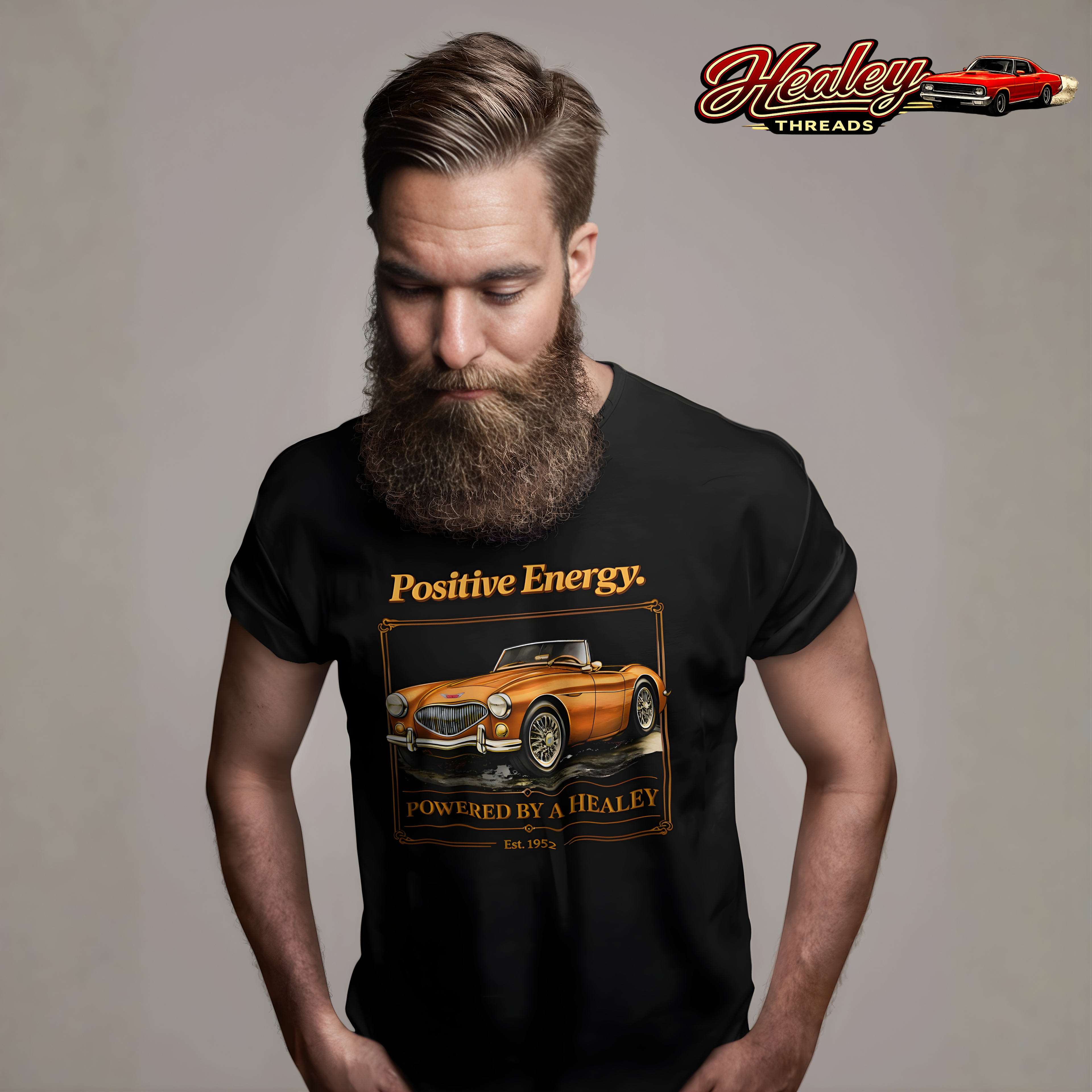 Man wearing a black t-shirt with a classic car graphic and text, standing against a plain background with 'Healey Threads' branding.