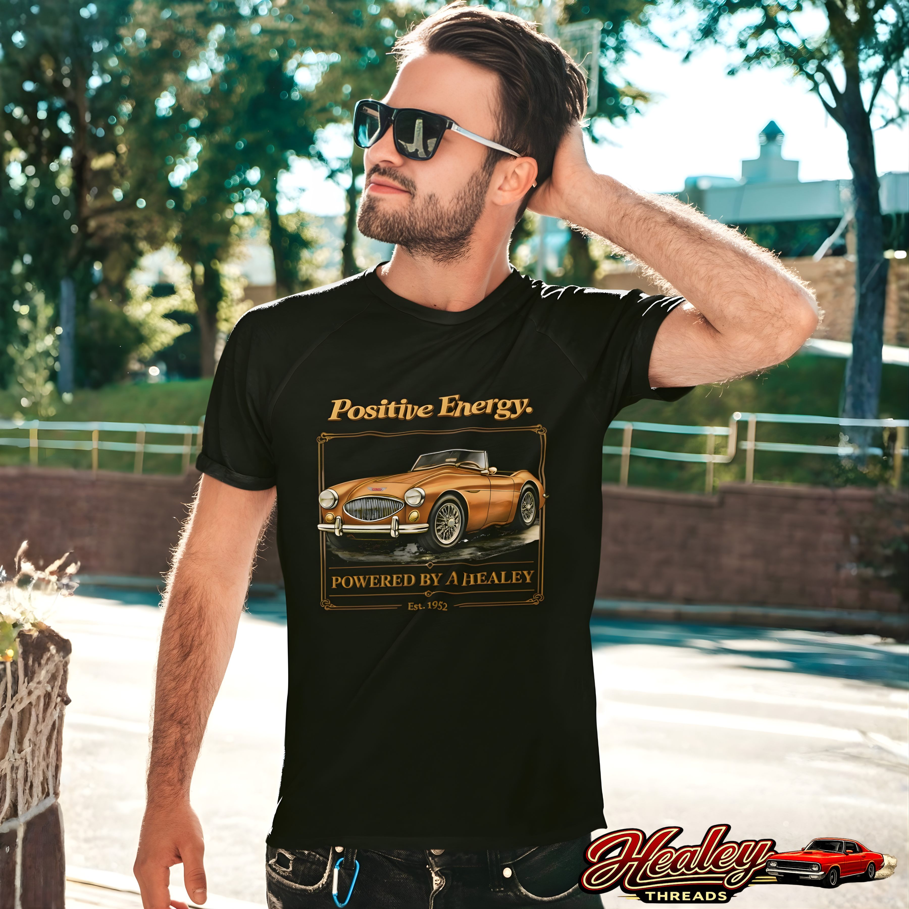 Man wearing a black t-shirt with a classic car graphic and 'Positive Energy' text, standing outdoors.