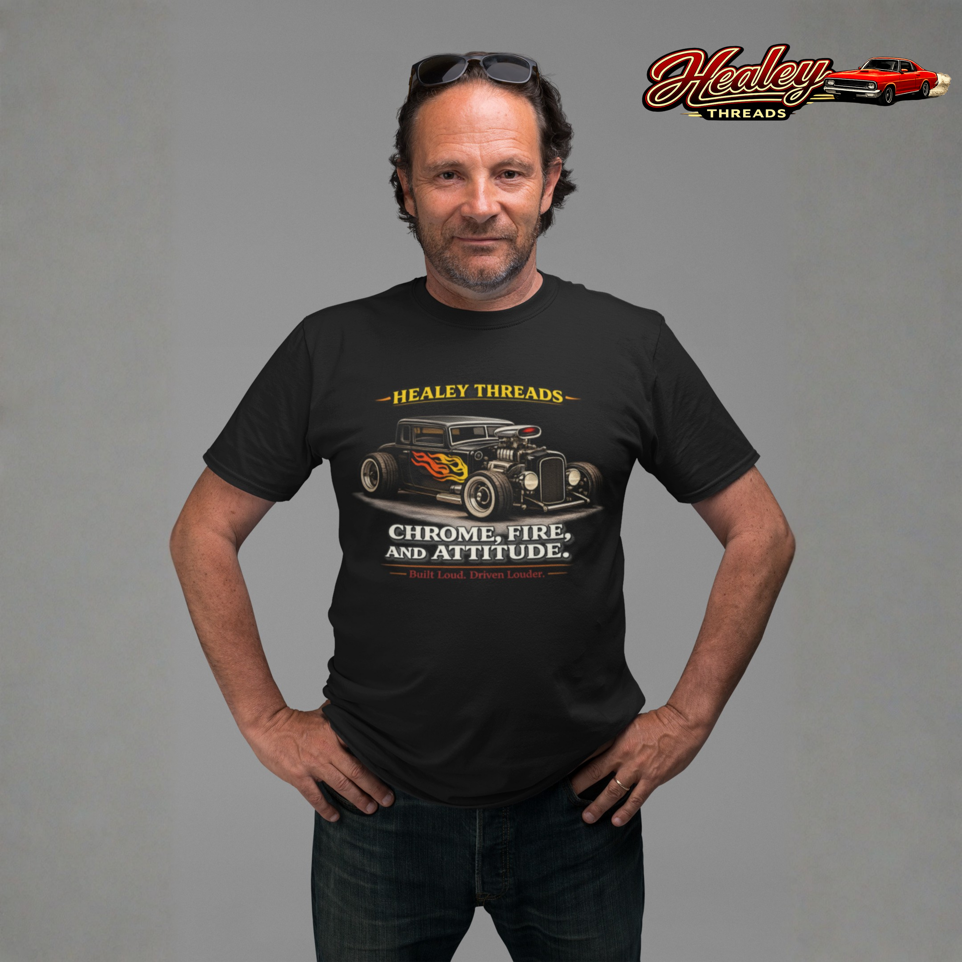 Man wearing a black t-shirt with a hot rod car design and a 'Healey Threads' graphic on a gray background.