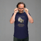 Man wearing a navy blue t-shirt with a graphic and text, holding glasses up to his face against a gray background.