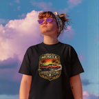 Woman wearing a black t-shirt with a graphic classic car design against a colorful sky.
