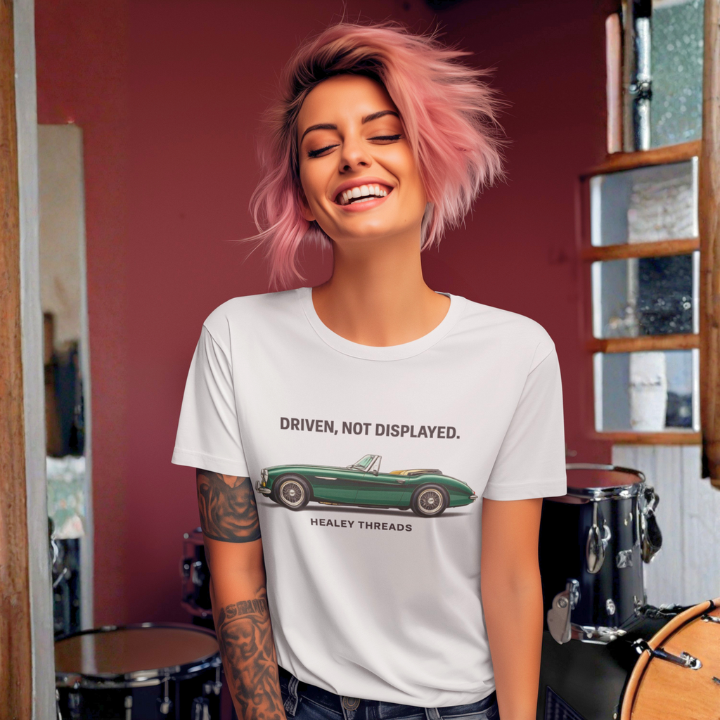 Woman wearing a white t-shirt with a classic car graphic design and text, standing in a room with musical instruments.