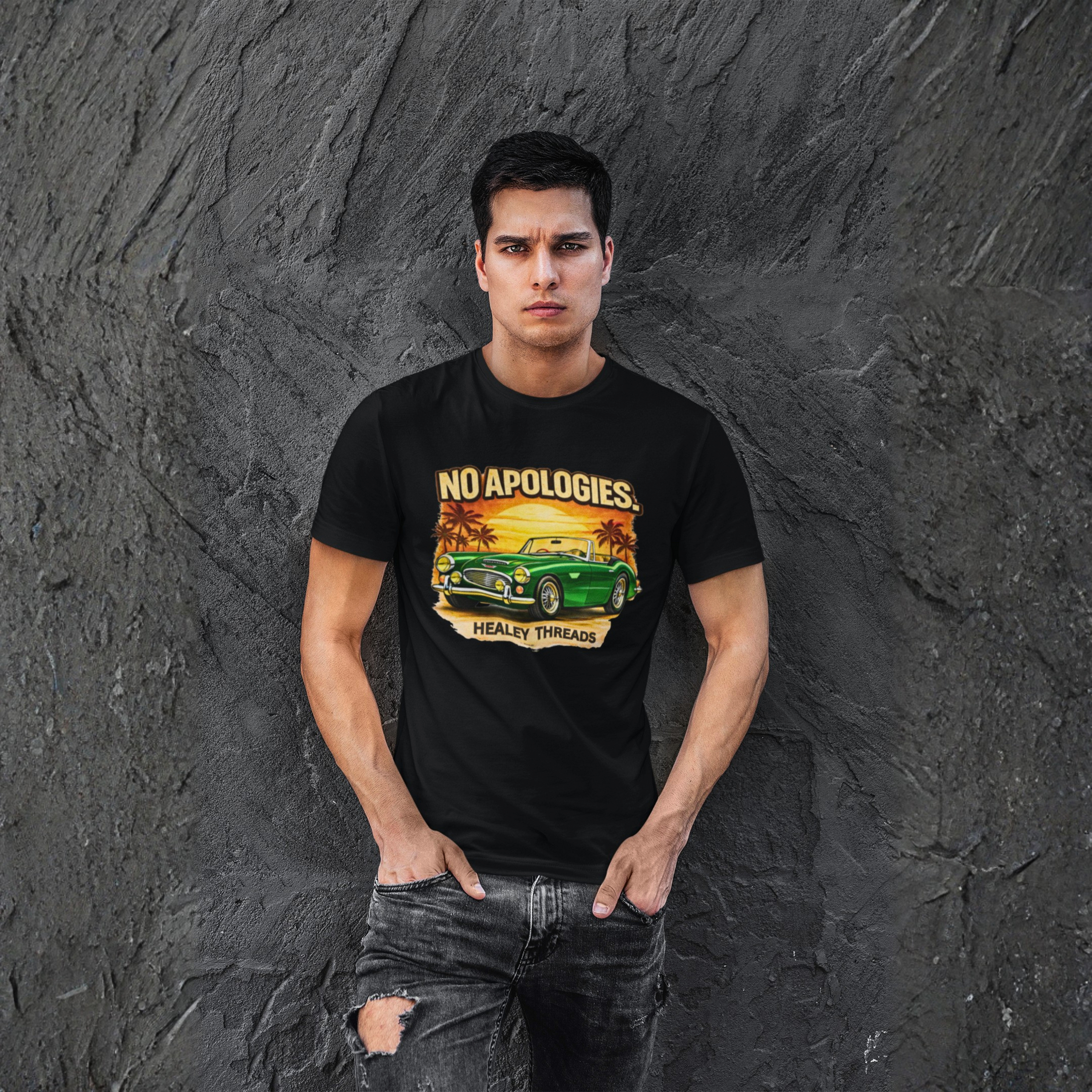 Man wearing a black t-shirt with a graphic Healey car design against a textured gray wall