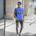 Man wearing a blue t-shirt with a classic car graphic design, standing on a city street.