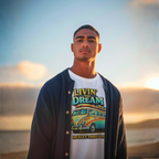 Man wearing a white t-shirt with a van graphic and text, standing against a sunset sky.