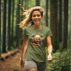 Woman wearing a military green t-shirt with a graphic design of a van and text, running through a forest.