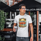 Man wearing a t-shirt with a graphic van design, holding a coffee cup, standing outdoors.
