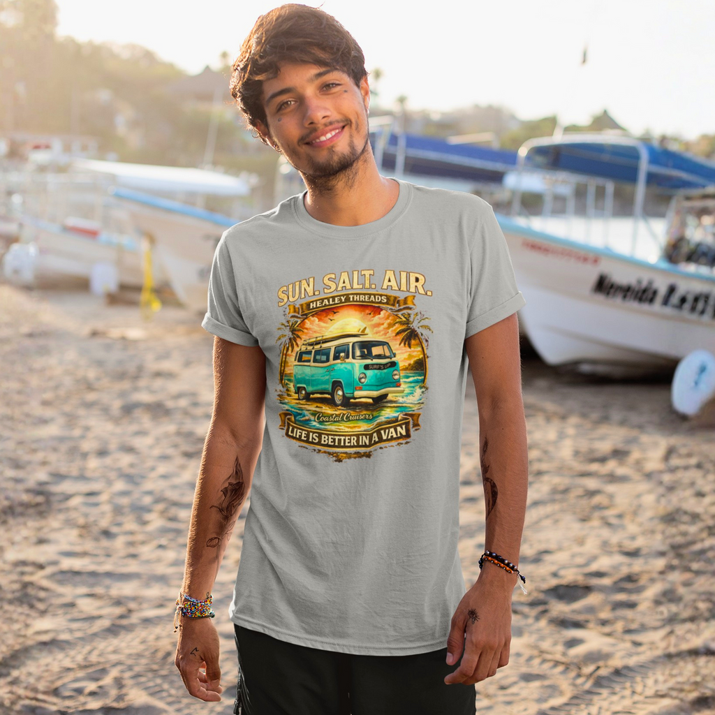 Man wearing a sport gray t-shirt with a van and beach-themed graphic and text on a sandy background