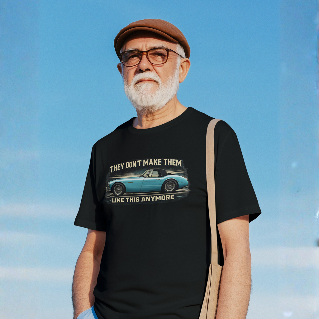 Man wearing a black t-shirt with a graphic Healey and text against a blue sky.