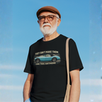 Man wearing a black t-shirt with a graphic Healey and text against a blue sky.