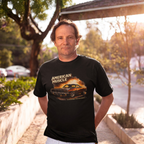 Man wearing a black t-shirt with 'American Muscle' graphic design outdoors.