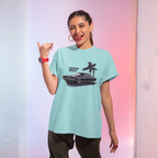 Woman wearing a light blue t-shirt with a graphic design, posing against a gradient background.