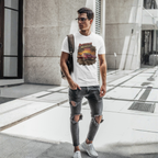 Man wearing a white t-shirt with a graphic design and ripped jeans, standing on a city street.