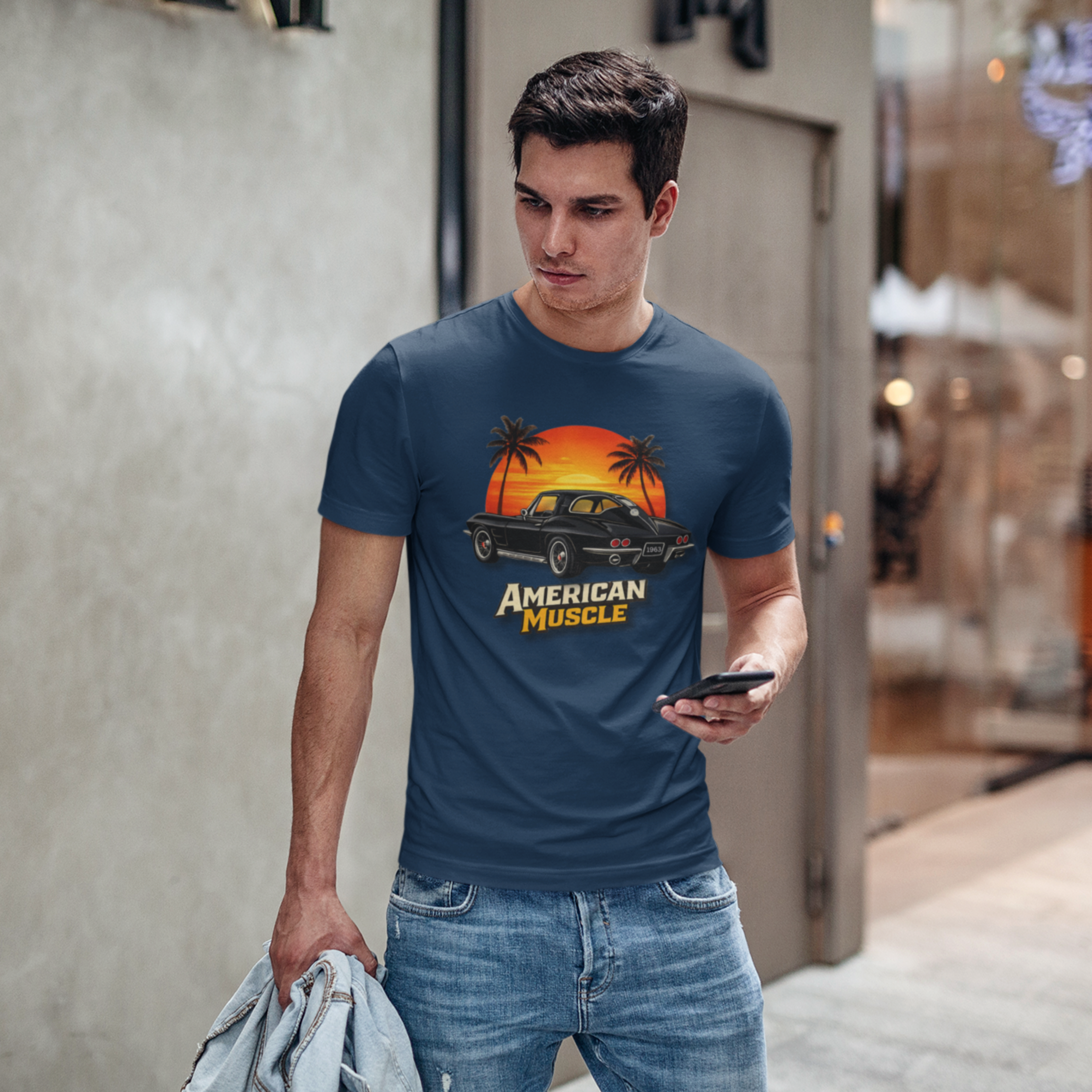 Man wearing a navy blue t-shirt with 'American Muscle' graphic design, standing outdoors.