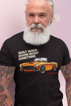 Man wearing a black t-shirt with a graphic of a classic car and text on a pink background