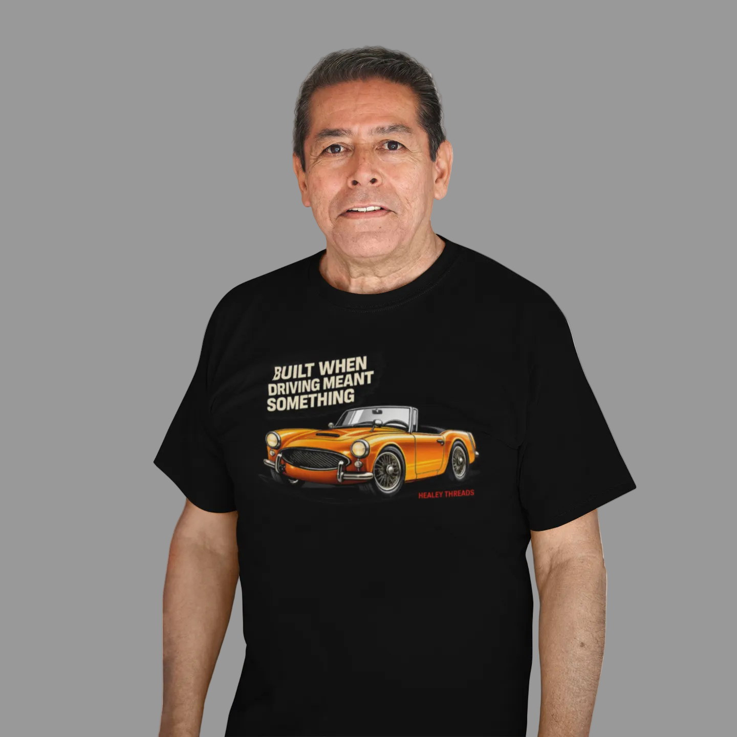 Man wearing a black t-shirt with a British classic car graphic design and text on a white background