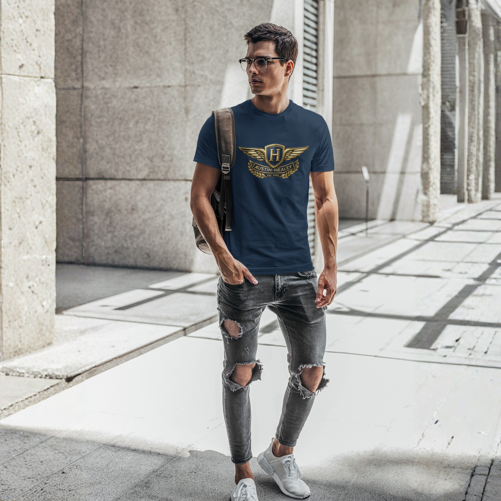 Man wearing a navy blue t-shirt with a Austin Healey logo and ripped jeans walking on a city street.