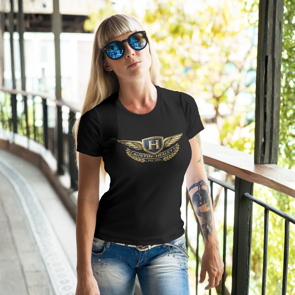 Woman wearing a black t-shirt with a Austin Healey logo, standing outdoors.