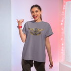 Woman wearing a gray t-shirt with a Austin Healey logo, posing against a gradient background.