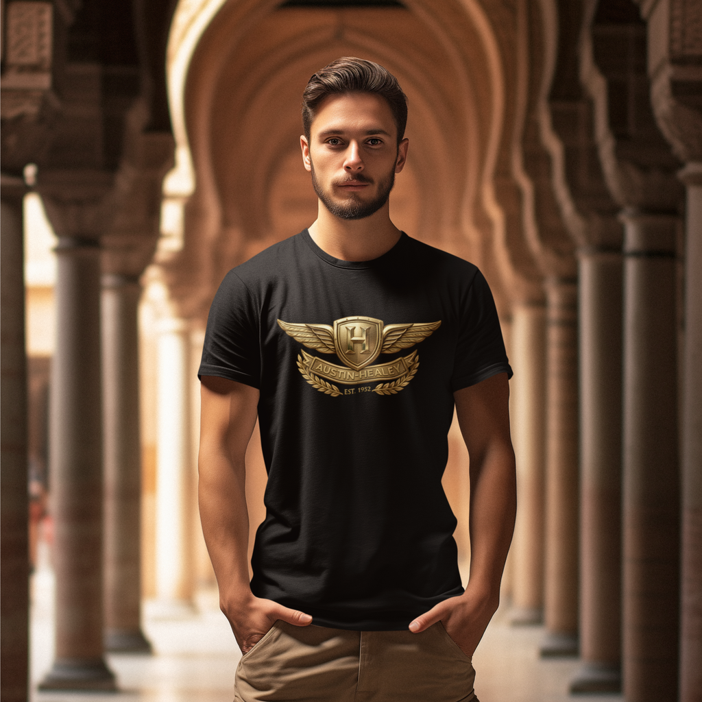 Man wearing a black t-shirt with a gold Healey emblem in an architectural setting