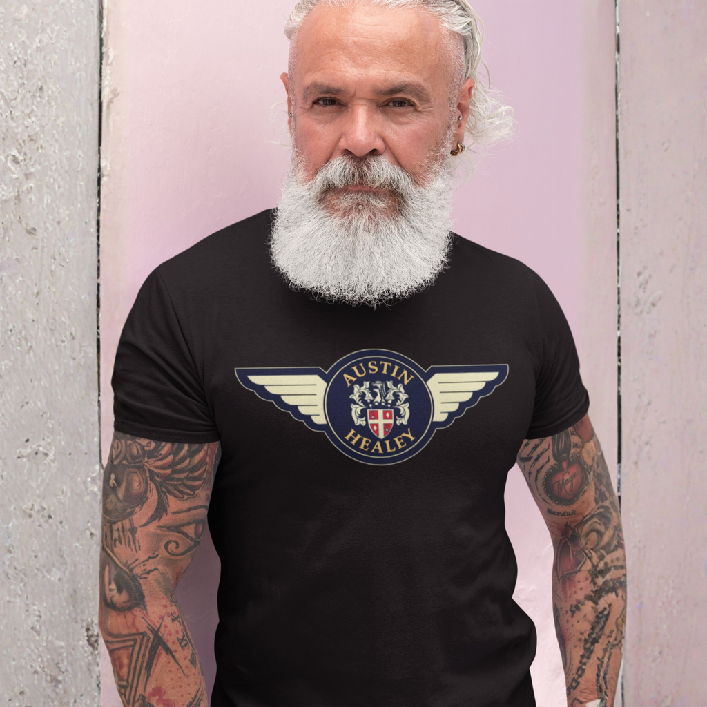 Man wearing a black t-shirt with Austin Healey logo against a pink and gray background