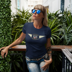 Woman wearing a navy blue t-shirt with a Austin Healey logo, standing outdoors with greenery in the background.