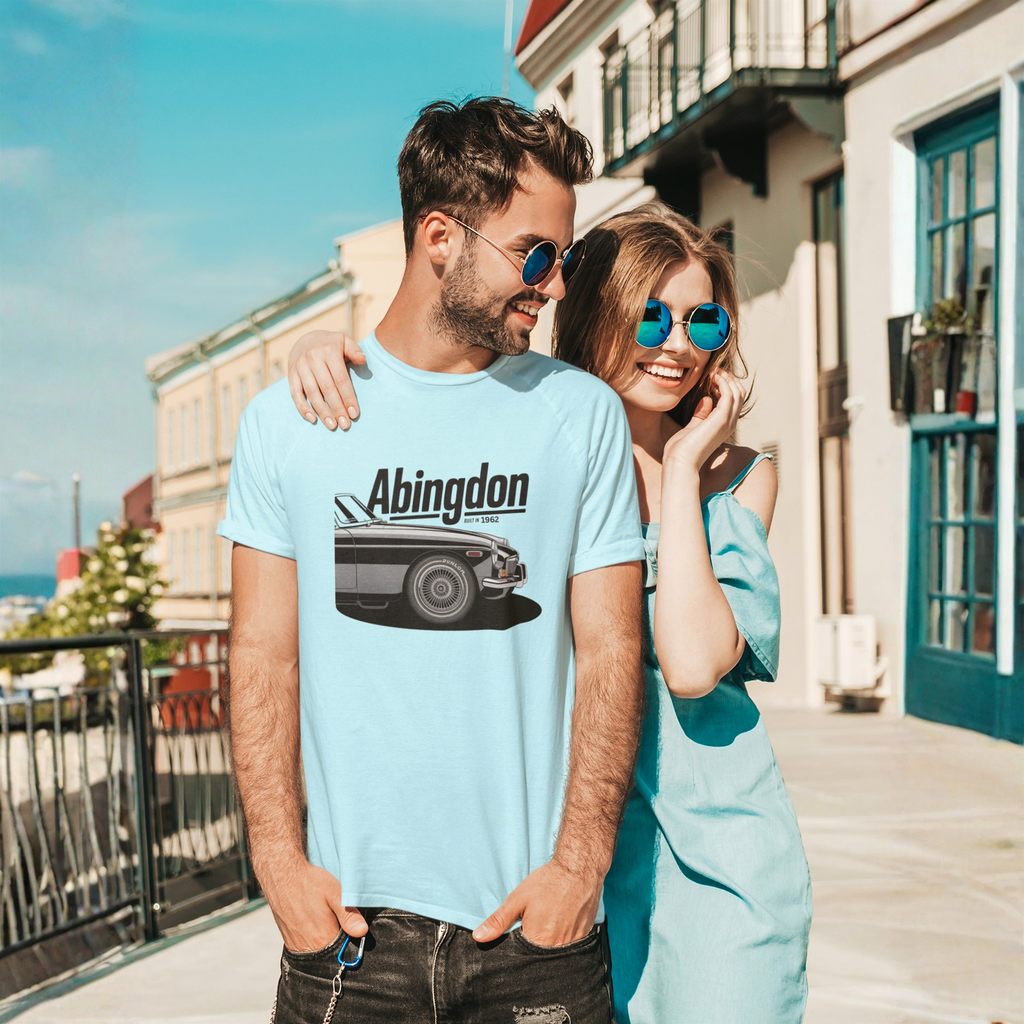Man and woman standing together on a sunny day, both wearing light blue shirts with a classic car graphic and 'Abingdon' text.