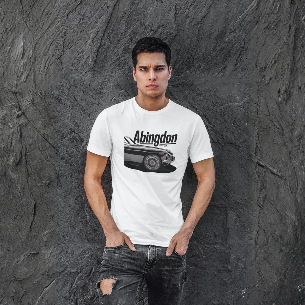 Man wearing a white t-shirt with 'Abingdon' and a classic car graphic against a textured gray wall.