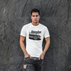Man wearing a white t-shirt with 'Abingdon' and a classic car graphic against a textured gray wall.