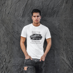 Man wearing a white t-shirt with a classic car graphic design against a textured gray wall