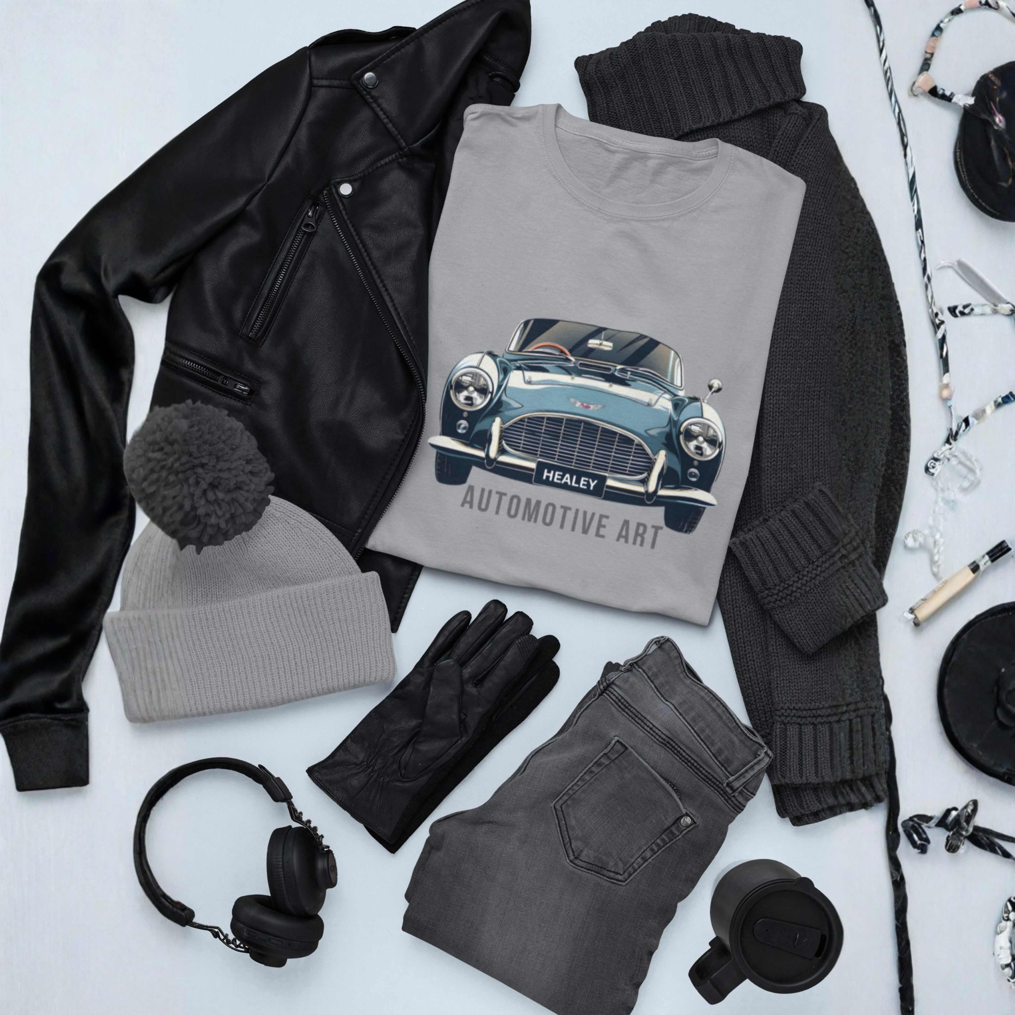 Collection of clothing and accessories including a sport gray t-shirt with a car design, jacket, beanie, gloves, jeans, and headphones on a light gray background.