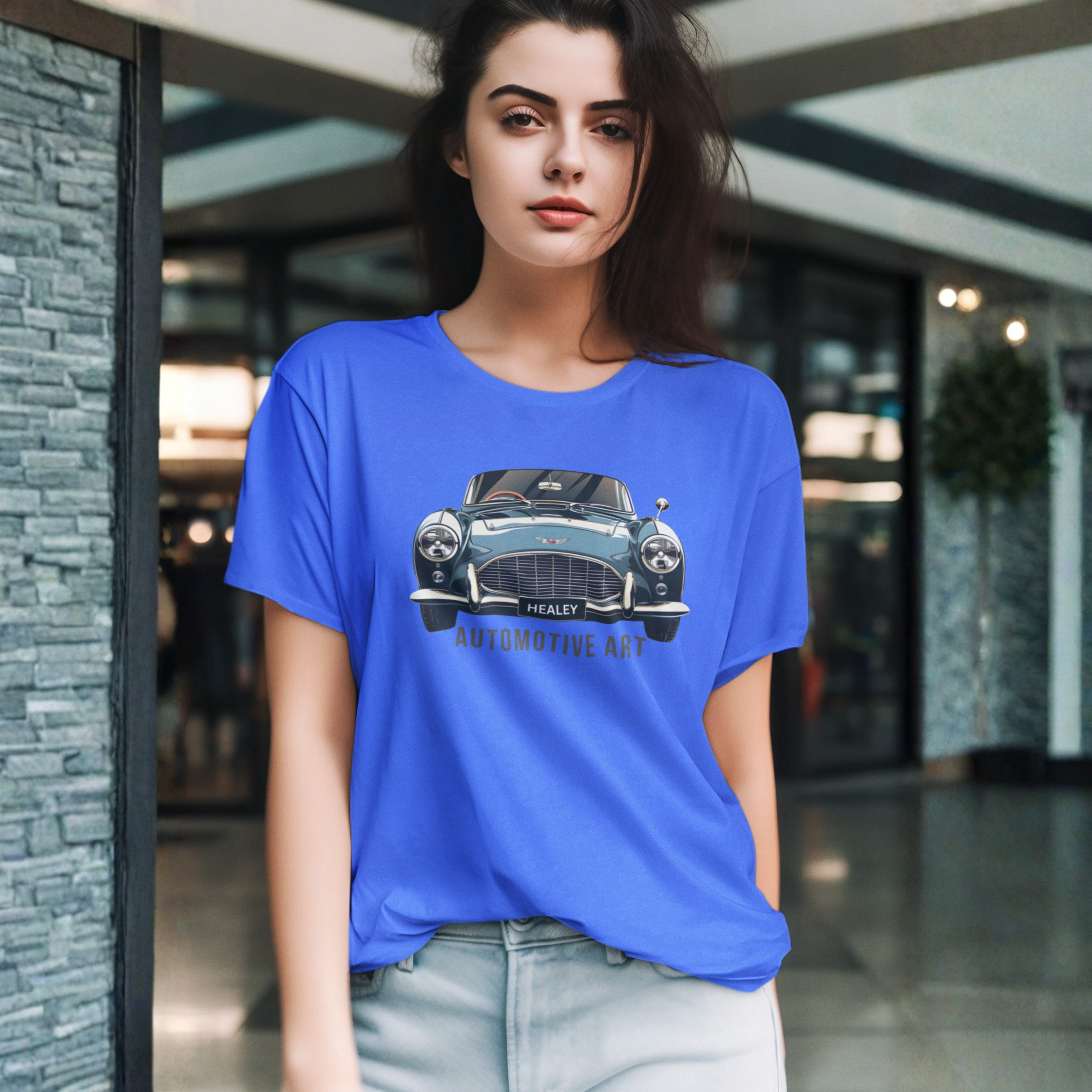 Woman wearing a royal blue t-shirt with a Healey car graphic in an indoor setting