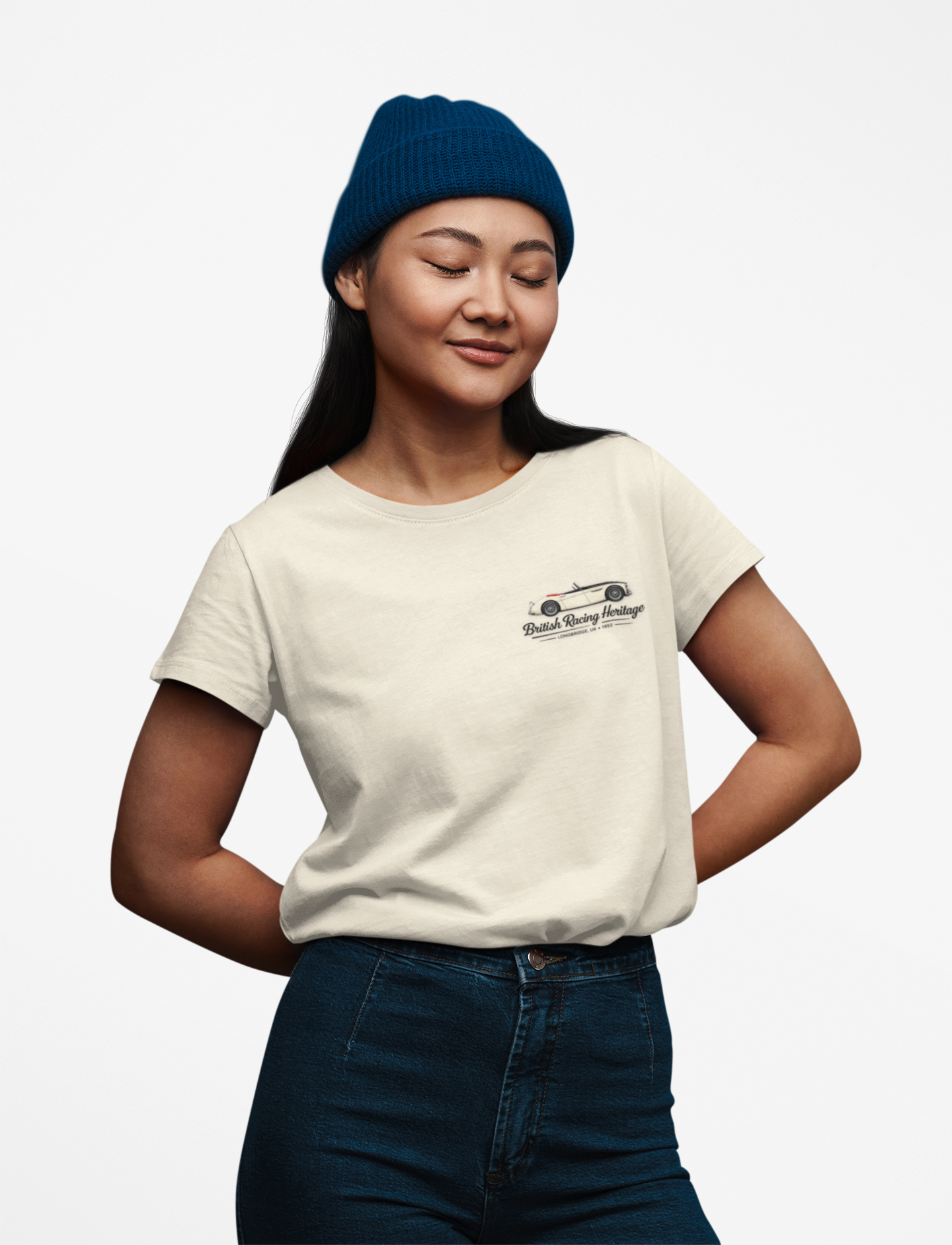 Girl wearing a white t-shirt with a Healey car graphic and black text with a blue beanie on a light background